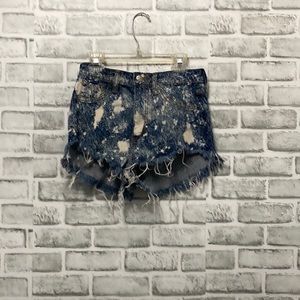 Jean shorts that are tye died blue and white.